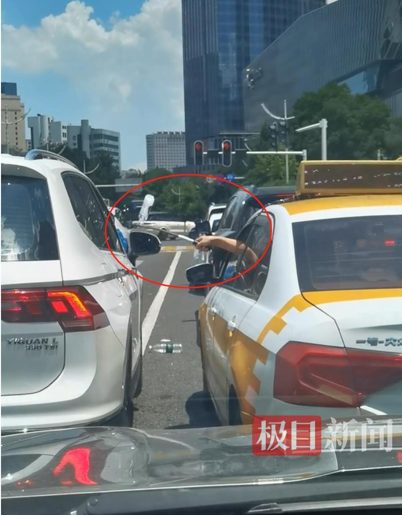 汉口街头发生不和谐一幕：白色汽车有人向出租车泼水 的哥挥舞甩棍击破白车玻璃……